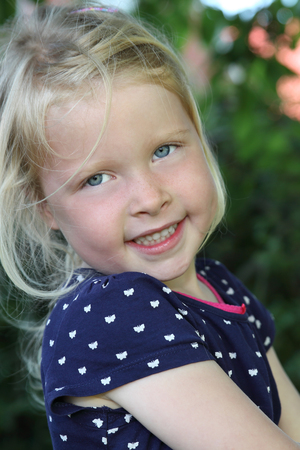 Portrait of a happy young girl outdoors in gardenの写真素材