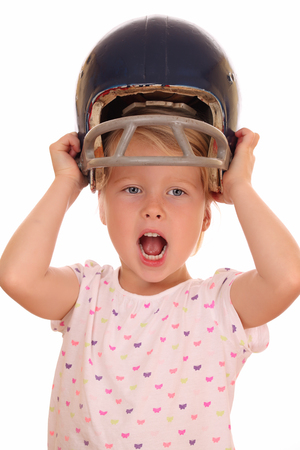 Portrait of a happy young girl with football helmet on white backgroundの写真素材