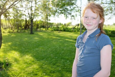 Portrait of a beautiful young girl outdoors in the gardenの写真素材