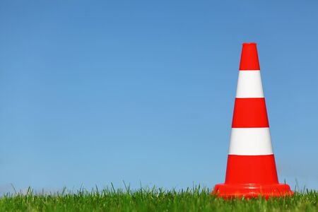 A single traffic cone on a green meadowの写真素材