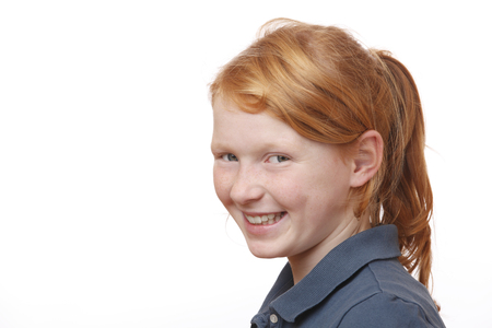 Portrait of a redhaired young girl with freckles on white backgroundの写真素材