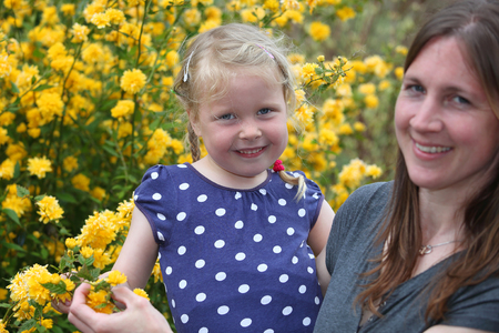 Happy mother and daughter enjoy the flowers in the gardenの写真素材