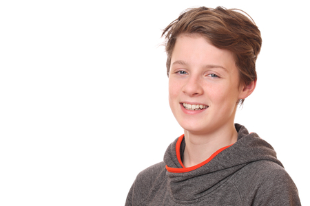 Portrait of a smiling teenage boy on white backgroundの写真素材