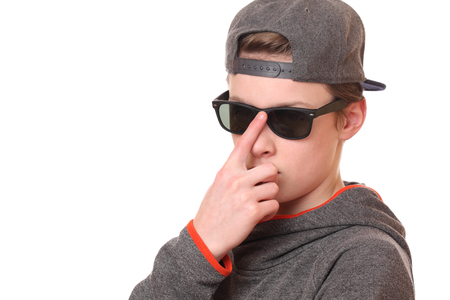 Portrait of a cool teenage boy wearing sunglasses on white backgroundの写真素材