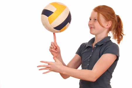 Portrait of a young girl with volleyball on white backgroundの写真素材