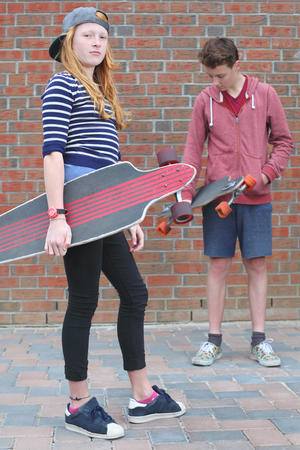 Portrait of two cool young teenagers outdoors with their skateboardsの写真素材