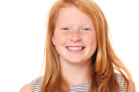 Portrait of a smiling young girl on white backgroundの写真素材