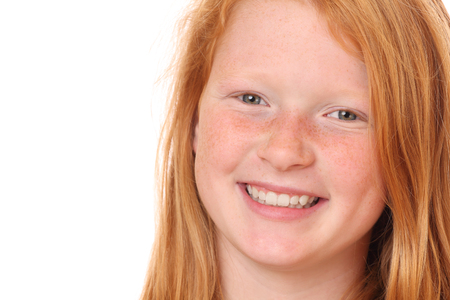 Portrait of a smiling young girl on white backgroundの写真素材