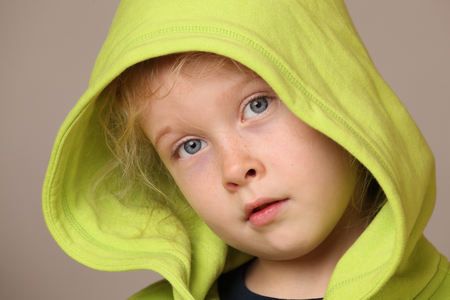 Portrait of a serious looking child girl on gray backgroundの写真素材
