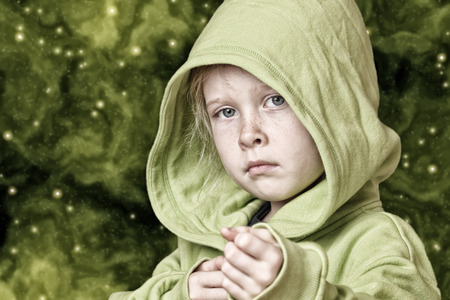 Portrait of a serious looking child girl on starfield backgroundの写真素材
