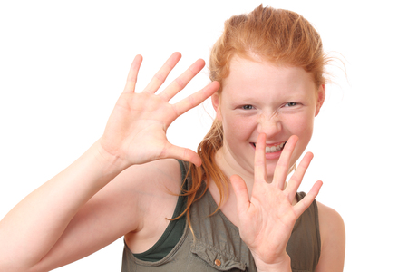 Portrait of a teenage girl showing stop gesture with hands on white backgroundの写真素材