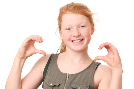 Portrait of a happy teenage girl with red hair on white backgroundの写真素材