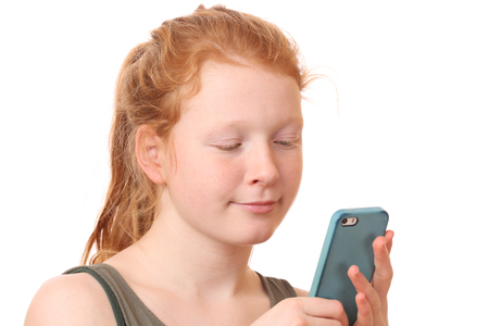 Portrait of a sad teenage girl holding mobile phone on white backgroundの写真素材