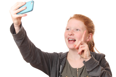 Portrait of a young girl taking a selfie on white backgroundの写真素材