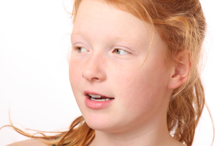 Portrait of a happy teenage girl with red hair on white backgroundの写真素材
