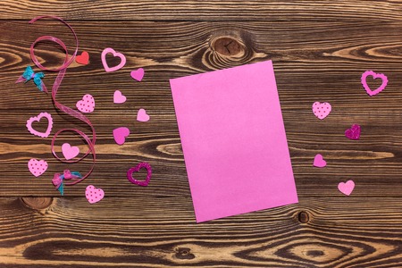 Valentines day toy heart and notepad paper page for your text. Top view on wooden tableの写真素材