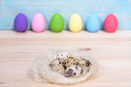 Easter eggs in nest on wooden background.の写真素材