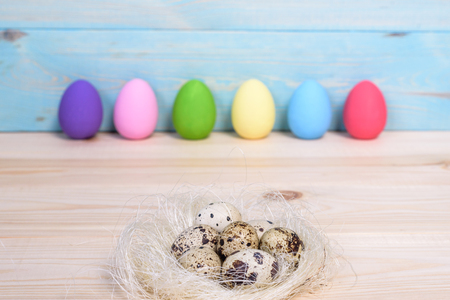 Easter eggs in nest on wooden background.の写真素材