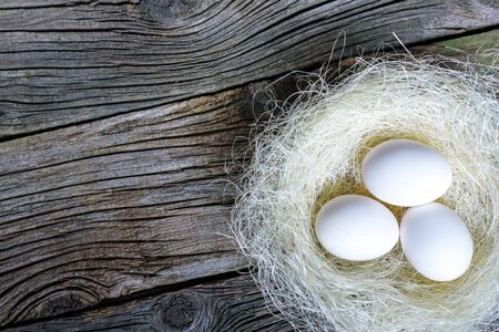 Easter eggs in nest over vintage wood. Top view with tag for copy spaceの写真素材