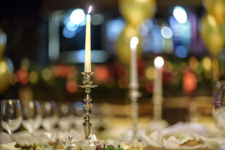 Glasses, forks, knives, napkins and decorative flower on a table served for dinner in cozy restaurantの写真素材