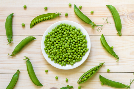 Green pea in bowl of top view on rustic wooden background with copy space, natural wooden table. Flat lay.の写真素材
