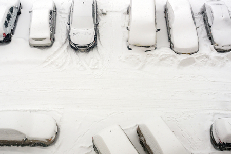 elevated view of new fresh snow covered cars in parking lot. top viewの写真素材