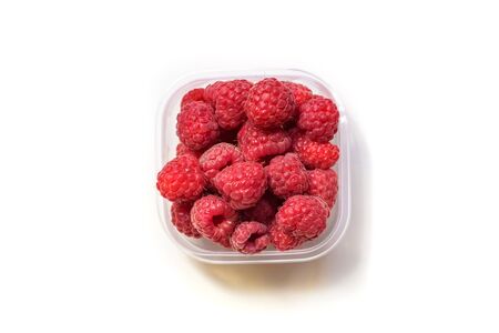 ripe raspberries in glass bowl isolated on white background