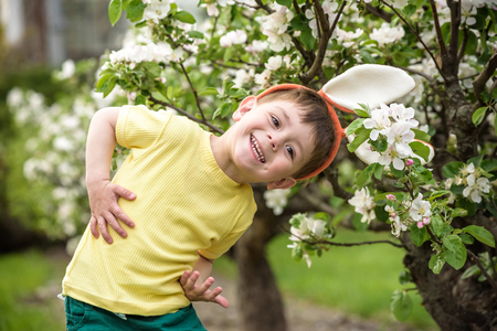 Little boy hunting for easter egg in spring garden on Easter day. Cute little child with traditional...