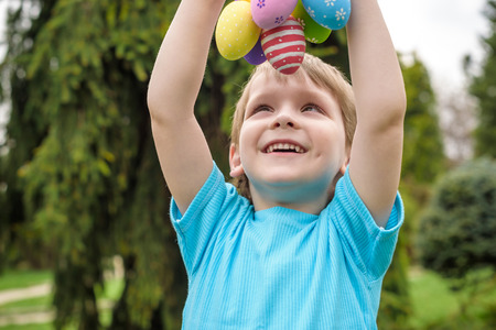 Different color Easter Eggs in a child's hands- egg hunt.