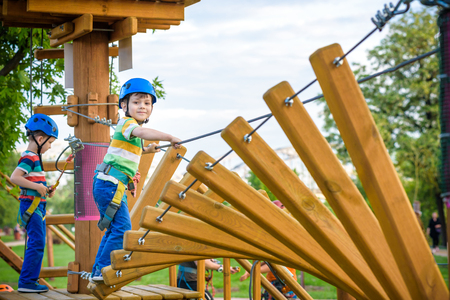 Young boy playing and having fun doing activities outdoors. Happiness and happy childhood concept. Boy swing on rope.の写真素材
