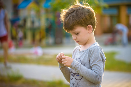 Happy mulatto boy child is smiling enjoying adopted life. Portrait of young boy in nature, park or outdoors. Concept of happy family or successful adoption or parenting.の写真素材