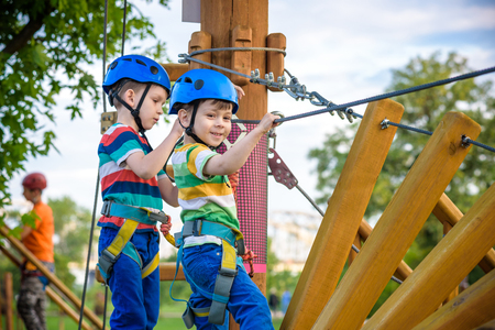 Young boy playing and having fun doing activities outdoors. Happiness and happy childhood concept. Boy swing on rope.の写真素材