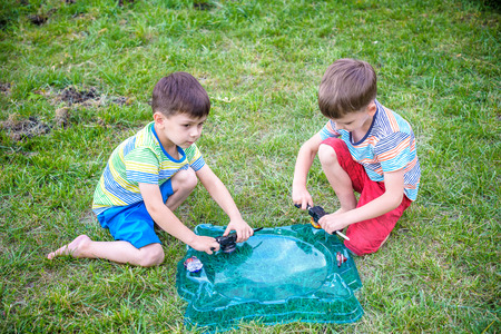 Two Boys playing with modern spin top outdoors. Entertainment game for children. Top, triggered by a...