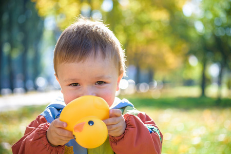 Emotional portrait of a happy and cheerful little boy laughing. yellow flying maple leaves while...