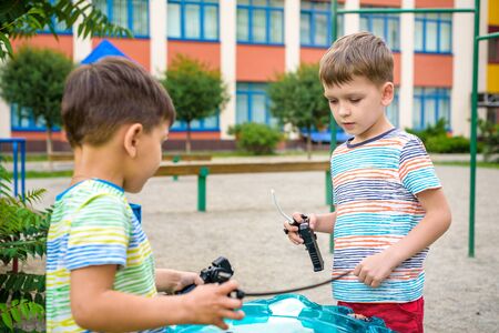 Two Boys playing with modern spin top outdoors. Entertainment game for children. Top, triggered by a...