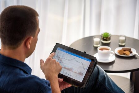 Businessman using digital tablet and drinking coffee. Smartphone Paper Cup Shirt Beard. Office...