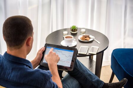 Businessman using digital tablet and drinking coffee. Smartphone Paper Cup Shirt Beard. Office...