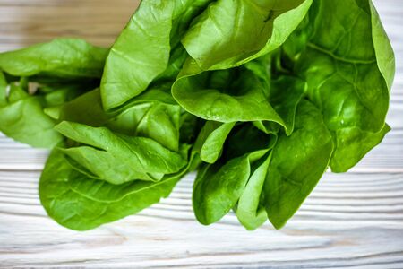 Head of fresh butter lettuce in a white bowl on a wood background.の写真素材