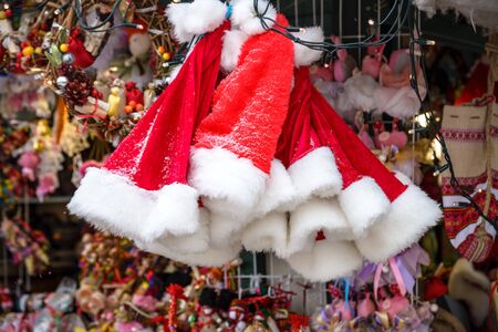 red Santa hats with snowflakes on the rack on market sell, new year and Christmas holidays.の写真素材