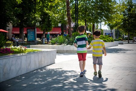 Group of happy children playing outdoors. Kids having fun in park during summer vacation. Friends walking in sunglasses and smiling. Summer holiday concept.の写真素材