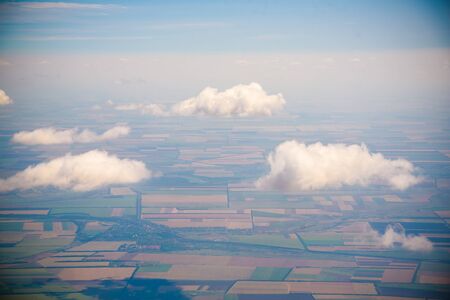 White fluffy clouds in the blue sky. Photos of clouds from the passenger liner porthole. Photo background.の写真素材