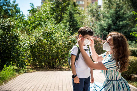 Family with kids in face mask going to school or kindergarten. Mother and child wear facemask during coronavirus and flu outbreak. Virus and illness protection, hand sanitizer in public crowded place.の写真素材