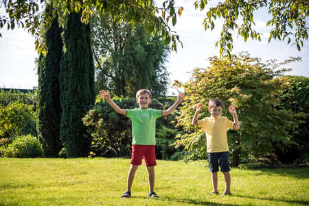 Group of happy children playing outdoors. Kids having fun in park during summer vacation. Friends walking in sunglasses and smiling. Summer holiday concept.の写真素材
