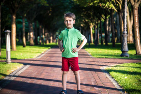 Awesome young happy boy portrait. The cute little kid is in the park posing wearing casual clothes.