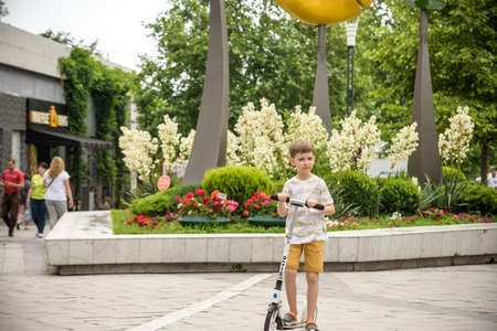 Odessa, Ukraine - July 05, 2021: Boy happy on a scooter in a city park.のeditorial素材