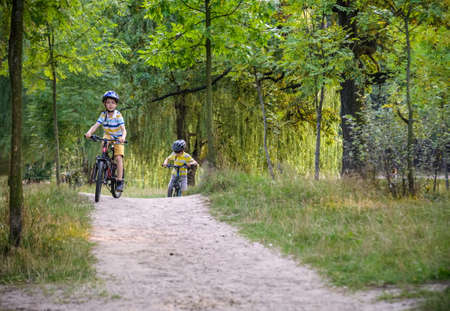 Two little boys children having fun on Balance Bike on a country road. Healthy lifestyle conceptの写真素材