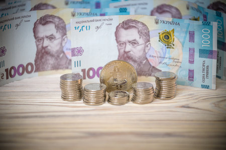 Bitcoin over the ukrainian hryvnia currency. Close up.