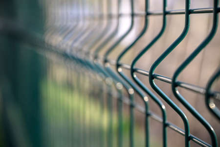 Fence made of steel bars. Fence made of netting in parking lot. Steel mesh. Obstacle from penetration.の写真素材