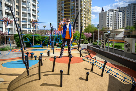 Children's obstacle course on a modern playground. Kid crossing a wooden bridge or other barriers using his body balance. Development of the child's agility and courage.の写真素材