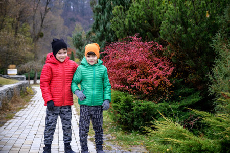 Close up portrait two happy positive kids boys, funny siblings fun together. Brothers playing outdoors in autumn day, best friends concept.の写真素材